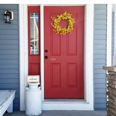 a red front door with a yellow wreath on it