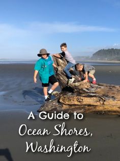 three boys on a log at the beach with text overlay reading a guide to ocean shores, washington