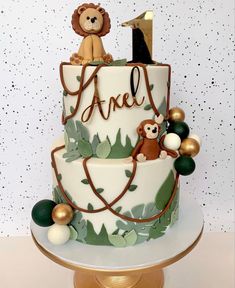 a two tiered cake with monkeys and leaves on the top, one is for an age