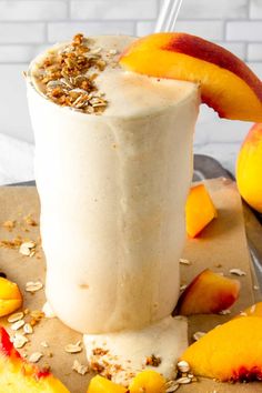 a smoothie with peaches and granola on the side is ready to be eaten