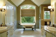 a large bathroom with two sinks and a bathtub in the middle of the room