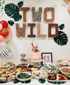 a table filled with lots of food next to a sign that says two wild on it