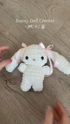 someone is holding a small stuffed animal on the floor and it looks like they have been made out of crochet