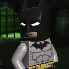 the lego batman movie character is standing in front of a dark background with green light