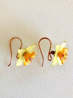 "Darling lightweight yellow daffodils with orange centers dangle on handmade natural copper hooks of 20 gauge German copper wire. Delicate lucite daffodil flower measures 20 mm wide and is embellished with bright orange lucite center flower and tiny lacey copper bead caps. Total length is 1\". Darling springtime accessory!" Orange Earrings For Spring Gift, Spring Gift Orange Earrings, Orange Daffodils, Lucite Flowers, Bright Copper, Daffodil Flower, Yellow Daffodils, Flowers Handmade, Earrings Flower