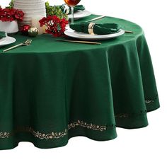 the table is set for christmas dinner with green linens