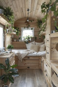 a bedroom with wooden walls and flooring has plants on the windows sill, while a bed is in the corner