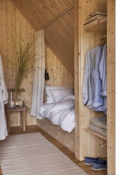 a bedroom with wooden walls and white bedding