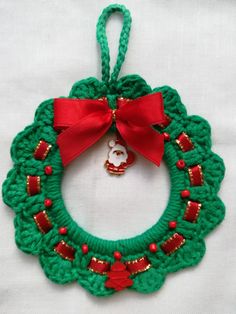 a crocheted christmas wreath ornament with a red bow