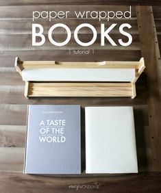 two books sitting on top of a wooden table next to a book holder with the title paper wrapped books