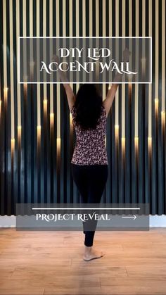 a woman standing in front of a wall with a sign that says diy led accent wall