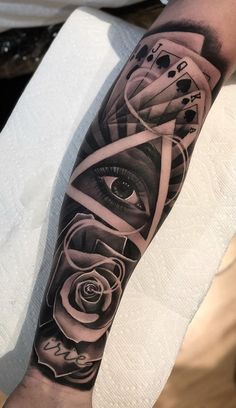 a man's arm with an all seeing eye and roses tattoo on the forearm