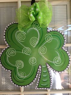 a st patrick's day door hanger with a green shamrock and polka dot bow