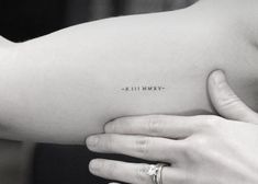 a woman's arm with an arrow tattoo on the left side of her arm