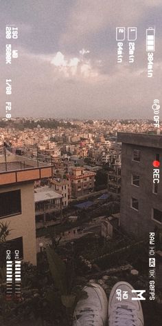 there are two pairs of shoes sitting on the ledge of a building overlooking a city