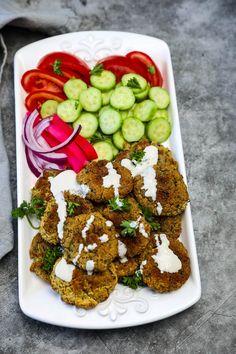 a white plate topped with veggies and meat patties