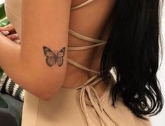 a woman with a butterfly tattoo on her arm