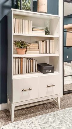 a white book shelf with books on it and a mirror in the corner behind it