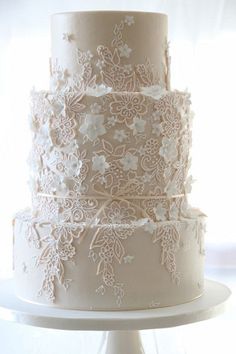 a three tiered cake with white flowers on the top and bottom is displayed in an instagram