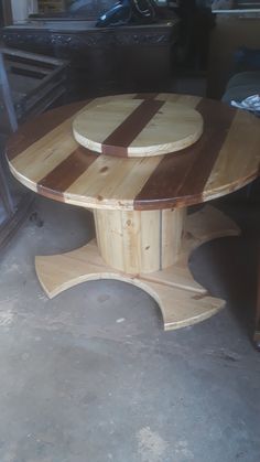 a round wooden table sitting on top of a floor