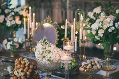 the table is set with candles, flowers and desserts for an elegant wedding reception