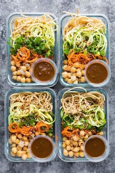 four plastic containers filled with food and sauces on top of a gray countertop