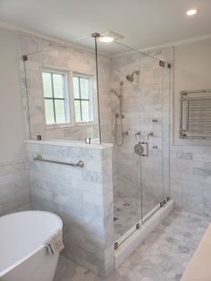 a bathroom with a tub, sink and shower in it's own area that is white marble