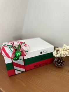 a christmas present sitting on top of a table next to a pine cone and candy