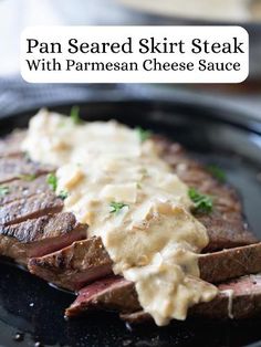 pan seared skirt steak with parmesan cheese sauce on a black platter