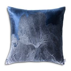 a blue and white pillow with leaves on it