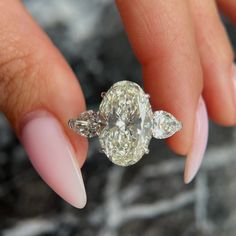 a woman's hand holding a diamond ring