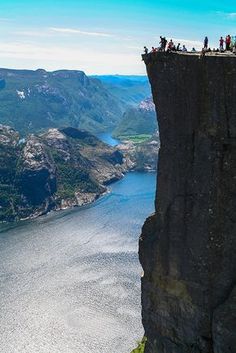 people are standing on the edge of a cliff