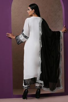 White straight kurta, accentuated with contrast black kashmiri aari embroidery. Paired with a pant with kashmiri aari embroidered hemline. Comes along with a scallop trimmed dupatta with kashmiri aari embroidered border.
Components: 3
Pattern: Embroidery
Type Of Work: Kashmiri Aari
Neckline: Round Neck
Sleeve Type: Three Quarter Sleeves
Fabric: Crepe, Georgette, Lining: Cotton
Color: White,Black
Other Details: 
Length:
Kurta: 48 inches
Pant: 38 inches
Approx. product weight: 1 kg
Model height: 5 Unstitched Elegant Churidar With Embroidered Border, Elegant Unstitched Churidar With Embroidered Border, Black Semi-stitched Salwar Kameez With Embroidered Border, Elegant Black Traditional Wear With Embroidered Border, Semi-stitched Black Churidar With Embroidered Border, Black Semi-stitched Churidar With Embroidered Border, Festive Black Unstitched Suit With Embroidered Border, Elegant Black Churidar With Chikankari Embroidery, Formal Anarkali Dupatta With Embroidered Border