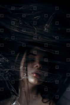 a woman's face is covered with plastic wrap and the image appears to be partially submerged in water