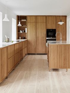 a large kitchen with wooden cabinets and white counter tops, along with an island in the middle