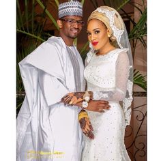 a man and woman dressed in white posing for the camera