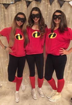 three women in red shirts and black pants posing for the camera with their hands on their hips