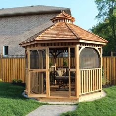 a wooden gazebo sitting on top of a lush green field