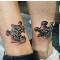 two people with matching tattoos on their legs holding pieces of a puzzle piece and wrench