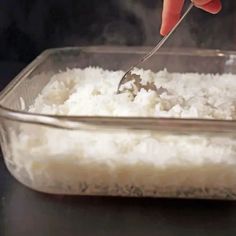 someone is spooning rice into a glass dish