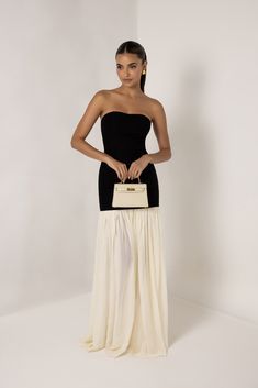 Introducing the Black Strapless Cream Chiffon Maxi Dress, a graceful blend of modern simplicity and timeless elegance. This stunning dress features a sleek, strapless black bodice that accentuates the shoulders and waist, providing a smooth and flattering silhouette. The bodice seamlessly transitions into a flowing cream chiffon maxi skirt that cascades to the floor, creating a soft, ethereal movement with every step. The contrast between the bold black top and the delicate cream skirt adds a sophisticated touch, making this dress perfect to dress down for the day or to dress up for formal events, galas, or evening soirées. Embrace effortless style with this versatile and elegant piece. Heiress Beverly Hills, Corset Pants, Chiffon Maxi Skirt, Cream Skirt, Dresses Xxl, Chiffon Maxi, Chiffon Maxi Dress, Bold Black, Blazer Dress