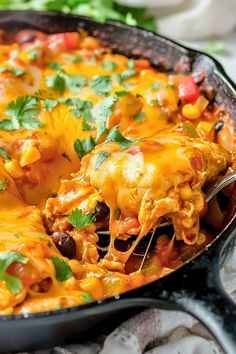 a casserole dish filled with mexican food and garnished with cilantro