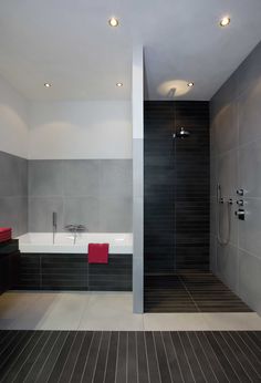 a bathroom with a tub, sink and shower head mounted to the side of the wall