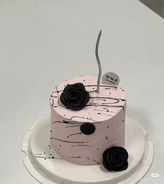 a pink cake with black flowers on it