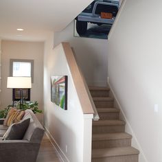 a living room filled with furniture and a fire place next to a stair case in front of a window