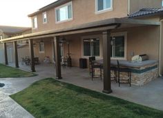 an outdoor patio with grill and hot tub