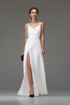 a woman wearing a white dress with a slit in the side