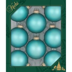 blue christmas ornaments in a box on a green background