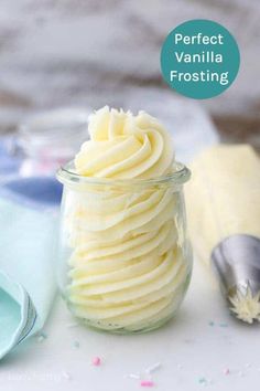 a jar filled with vanilla frosting next to a spoon