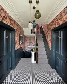 the hallway is decorated with black and white striped carpet, two chandeliers hanging from the ceiling